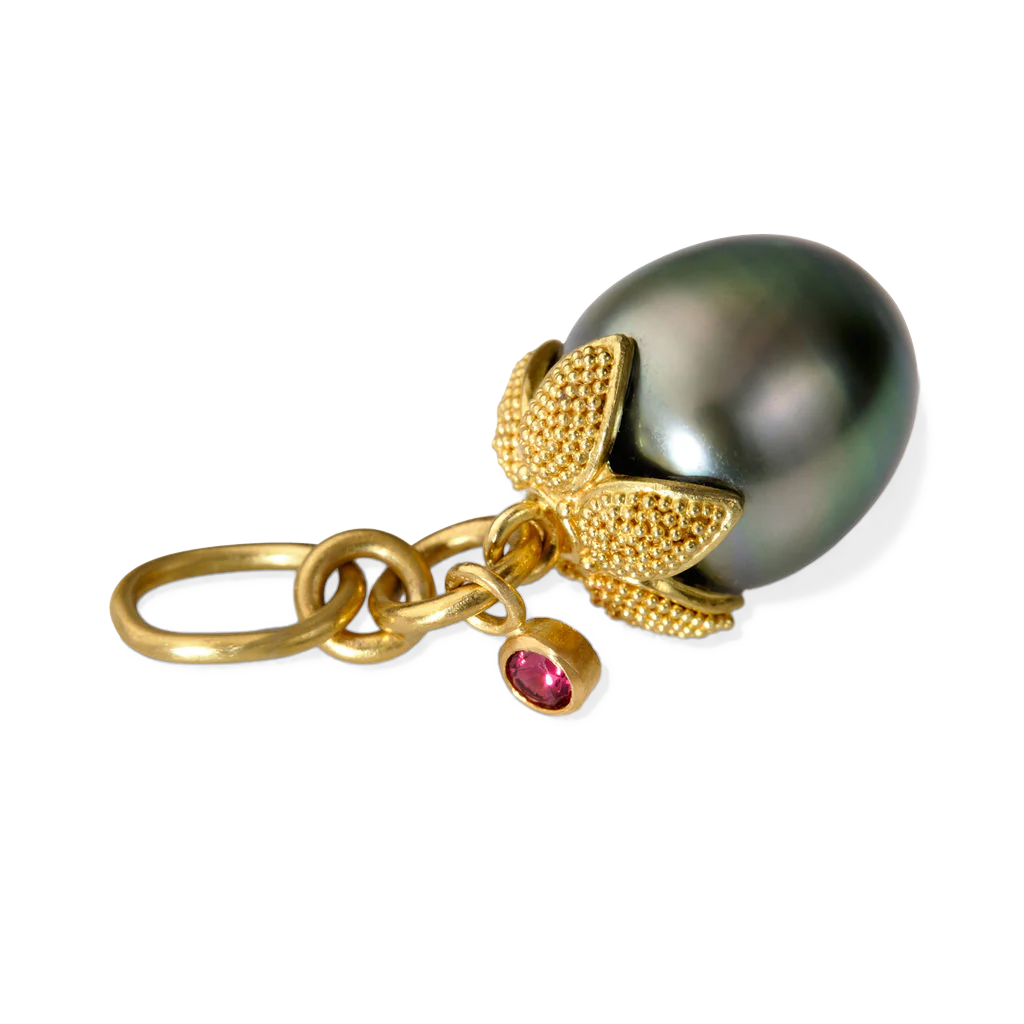 An exquisite acorn shaped metallic silver pearl is capped with a spectacular five-pointed granulated leaf that drapes over it. A floating deep red spinel glitters against the silken texture of the leaf, serving as a perfect foil for the subtle green tones in the pearl. One-of-a-kind. Length approximately 29mm, width 10.9mm (L 1.1in W .4in). Made from recycled 18k gold, a 10.9x12.2mm cultured Tahitian pearl and Burmese spinel (.08ct).