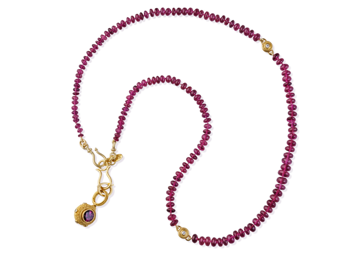 Gorgeous, one-of-a-kind necklace composed of rubellite tourmaline rondelle beads accented with handmade, granulated and diamond set beads. The rondelle's intense color is balanced by the richness and warmth of the gold beads and our signature "S" clasp fastens the strand. Pairs well with our Pink Tourmaline & Blue Akoya Pearl Cubic Studs. Length 18.5 inches.

Made with recycled 22k yellow gold, Rubellite tourmaline (66ct) and Canadian diamonds (.12ct). Knotted on silk.
