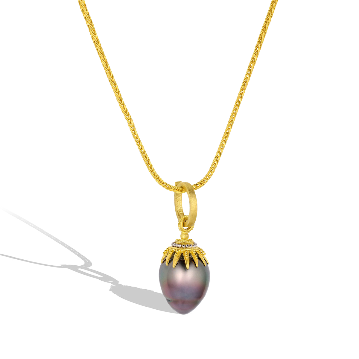 The Black Pearl Spider charm shown on a handwoven gold chain.