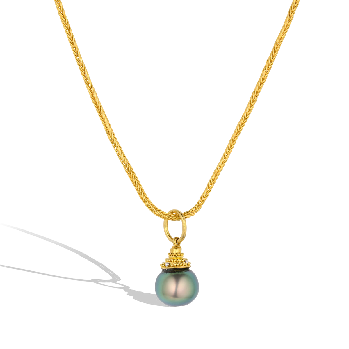 The Blueberry Pearl charm shown on a handwoven gold chain. The chain is available separately. One-of-a-kind.