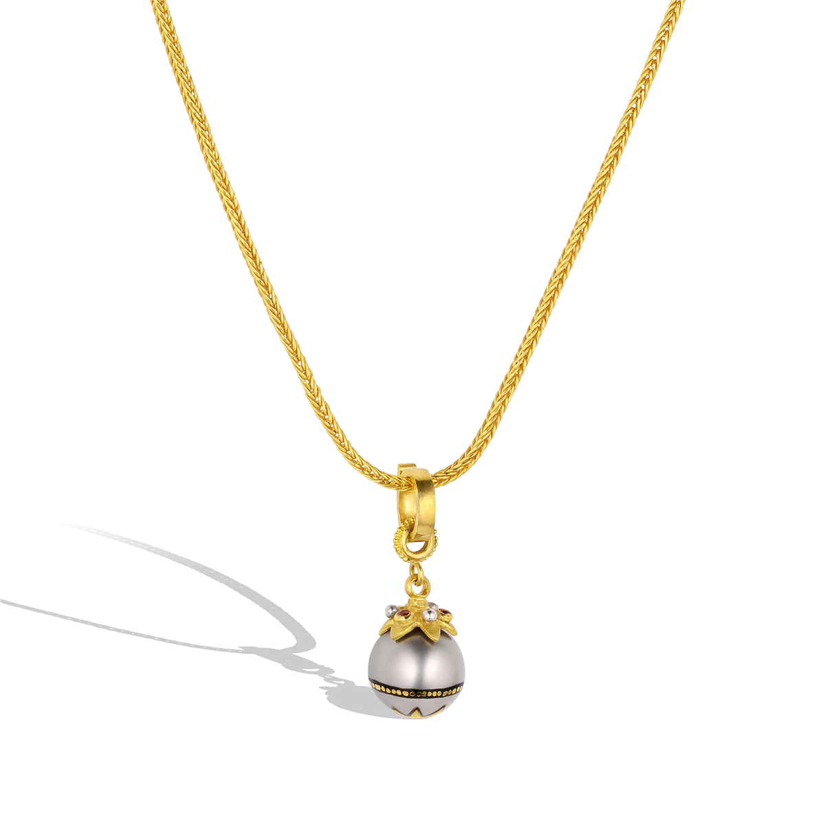 The Maki-e pearl charm with orange zircons on a handwoven chain.