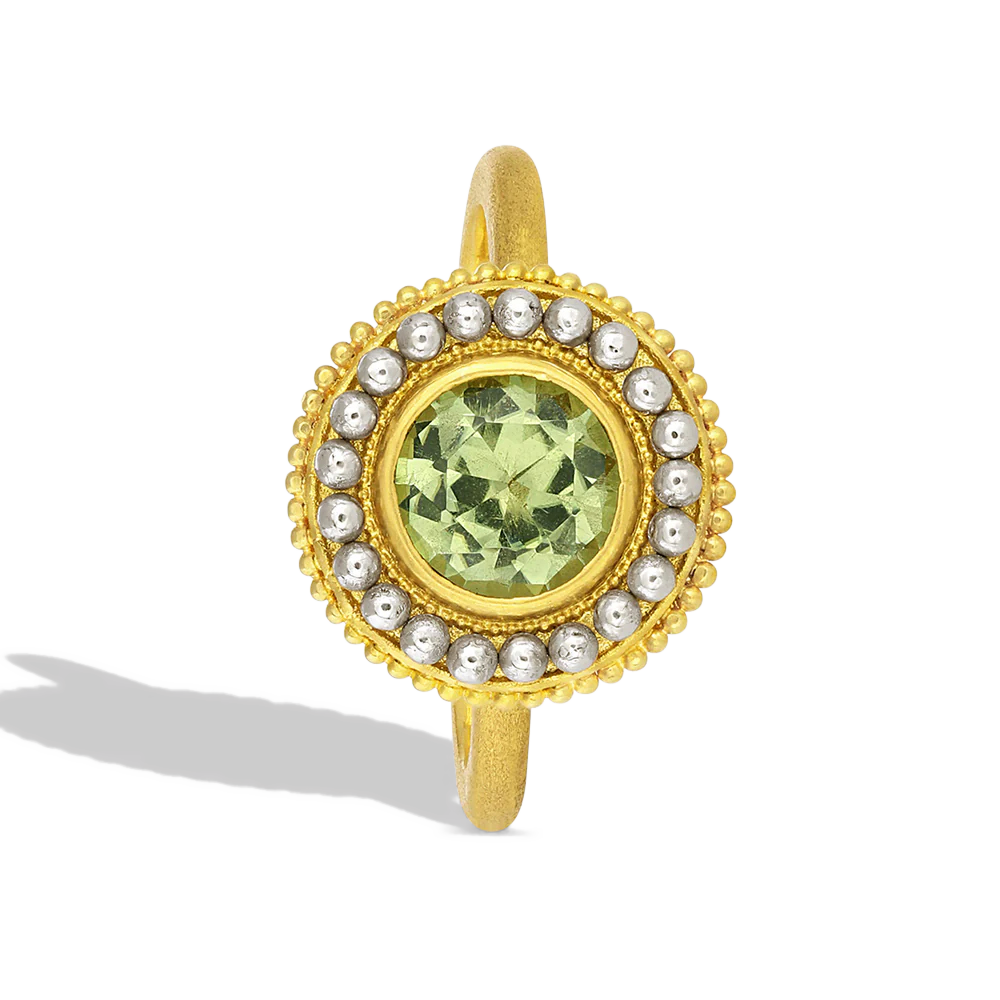 This unusual martini glass shaped ring features a light spring green tourmaline (1.19ct) with a beautiful metallic luster. The 'glass' is covered in gold granulation, giving volume and a soft feel to the fingertips. A sparkling 'salt' rim of oversize platinum granules highlights the metallic luster in the tourmaline. The ring band has a soft, parchment like feel. One-of-a-kind.

Made in recycled 22k yellow gold and platinum and a Moyo Gems tourmaline. Size 7.