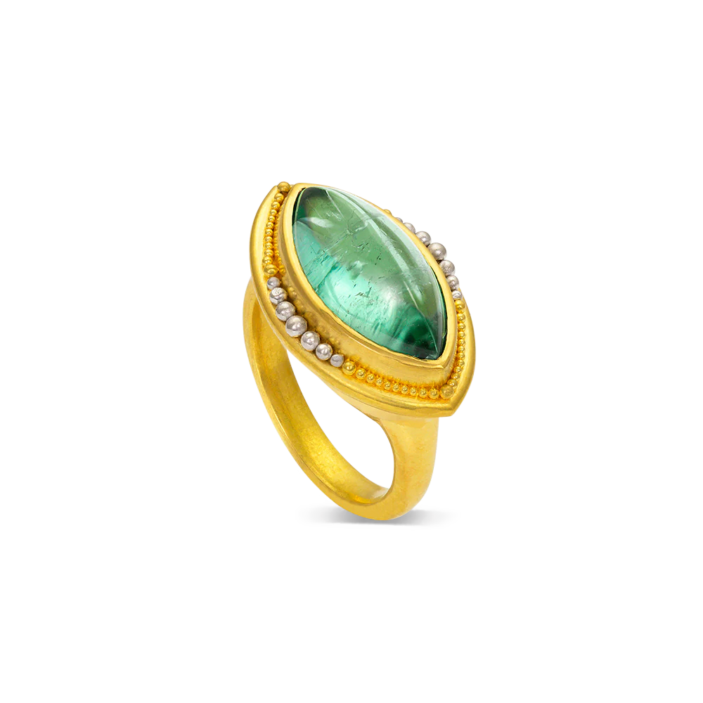 Stunning one-of-a-kind marquise shape deep blue green tourmaline edged with our signature gold and polished platinum granulation. This a beautiful gemstone, the color reminiscent of crystal-clear tropical seas surrounded by tiny sand grains of gold granulation.

Made in 22k yellow gold and platinum and a Nigerian tourmaline (5.88ctw). Size 7. Can be resized.