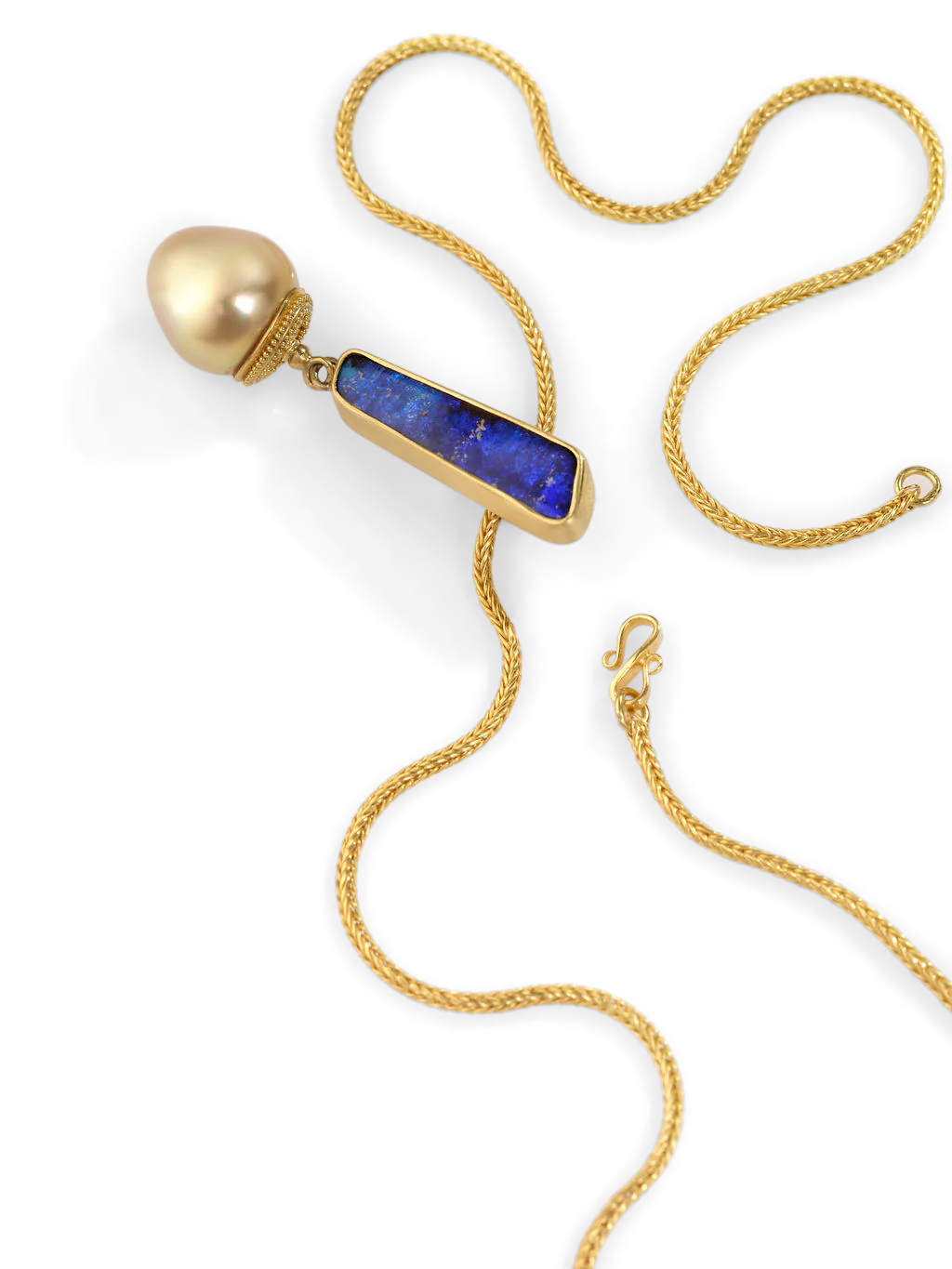 intensely colored, exclamation mark shaped boulder opal (5.38ct) sits atop a richly glowing golden triangular South Sea Pearl. The pearl's rich golden hue is accented by the granulated and curved oval cap, the tiny gold granules echoing the softly rounded pearl.
Made from recycled 22k gold, a Philippine South Sea Pearl (12.4x13.2mm) and an Australian boulder opal. Chain is available separately. Length approximately 53mm, width 10.89 (L 2in W .4in).