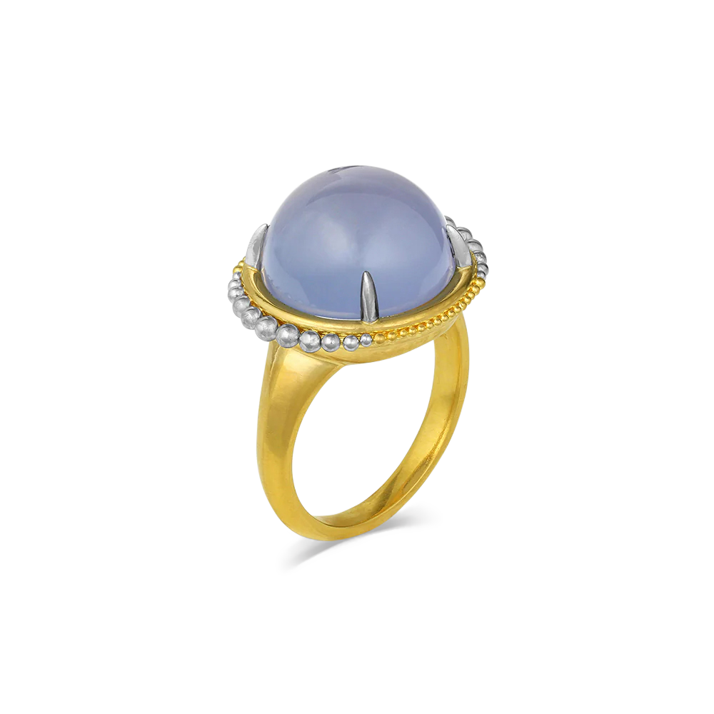 Mysterious lavender blue chalcedony (11.75ct) cut in a high round cabochon is set with delicate, barely-there platinum prongs and surrounded by sparkling platinum and gold granulation floating orbit-like around it. One-of-a-kind.

Made in recycled 22k yellow gold and platinum and Namibian chalcedony. Size 7.