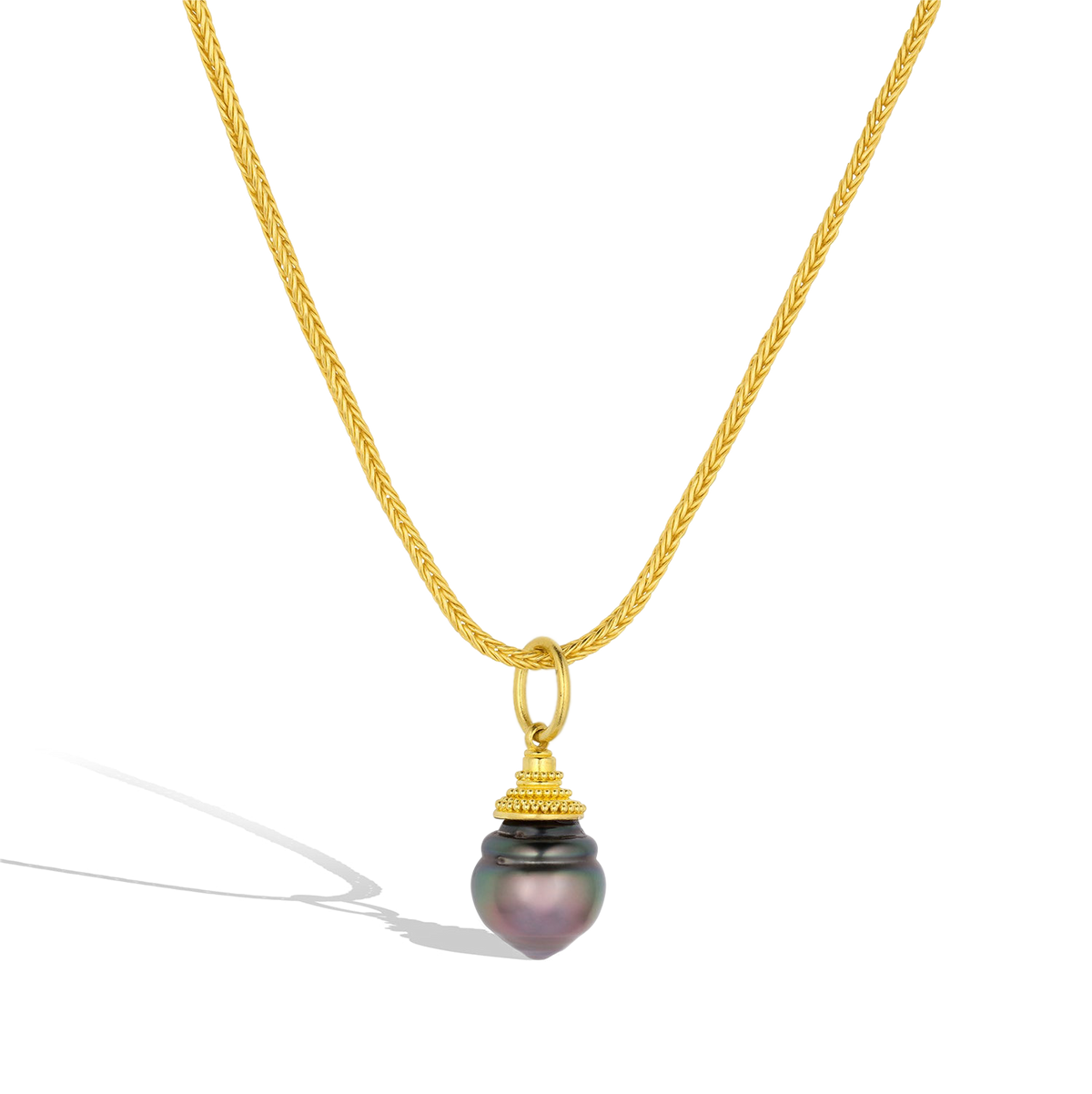 The Purple Circlé charm shown on a handmade woven gold chain.