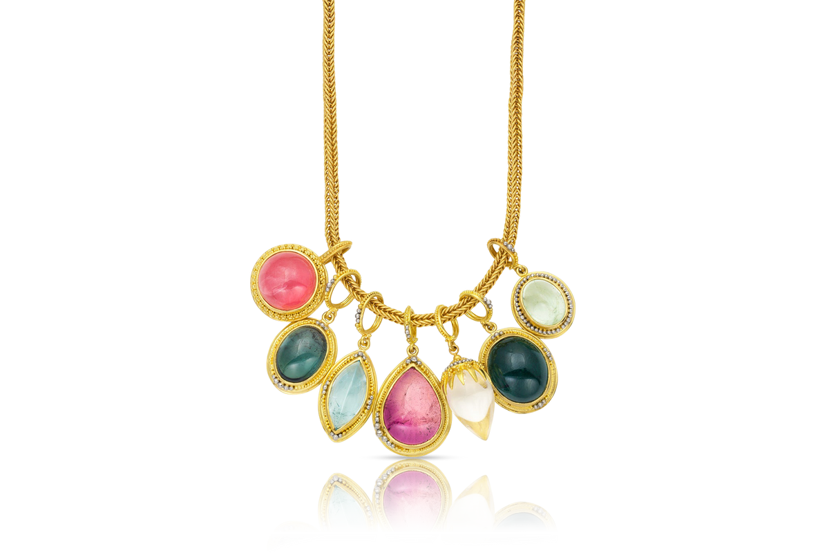 Revival Charms on a handwoven gold chain. The Green Tourmaline Revival charm is second from the right.