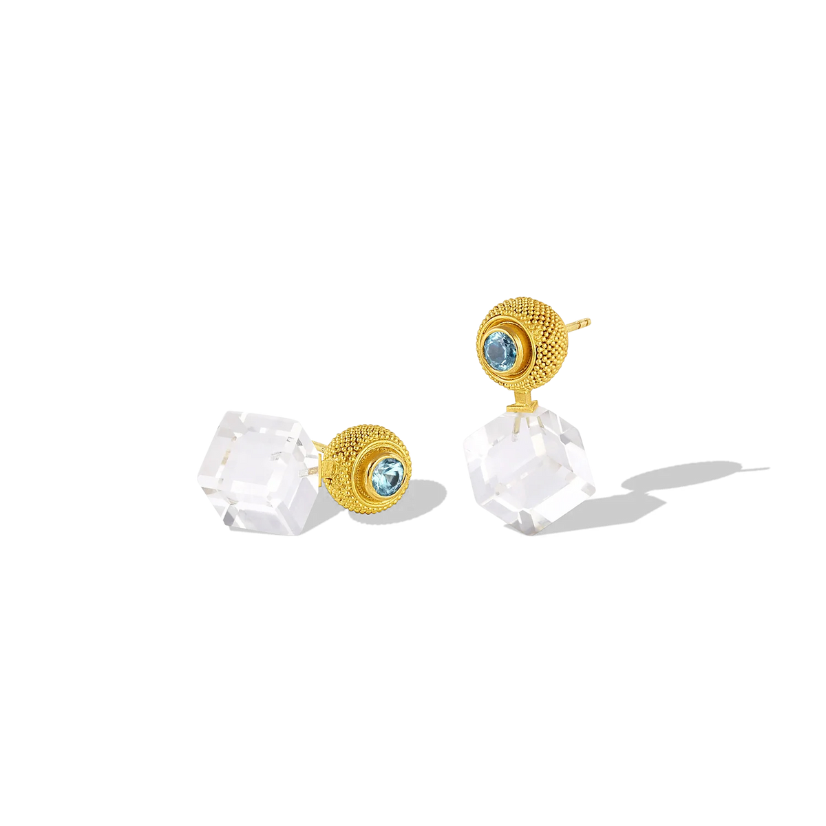 This variation on the classic stud earring has the silky appearance of a velvet cushion. The gold granules are  smooth and almost soft to the touch, giving an almost hypnotic feel to the fingertips. The rich, buttery mellow tone of the yellow gold soften the bold, angular and contemporary lines of the custom cut rock crystal cubes and the glittering blue zircons provide a vivid pop of color. 

Made from recycled 22k gold, Cambodian zircon (.83ctw) and rock crystal (18.91ctw).