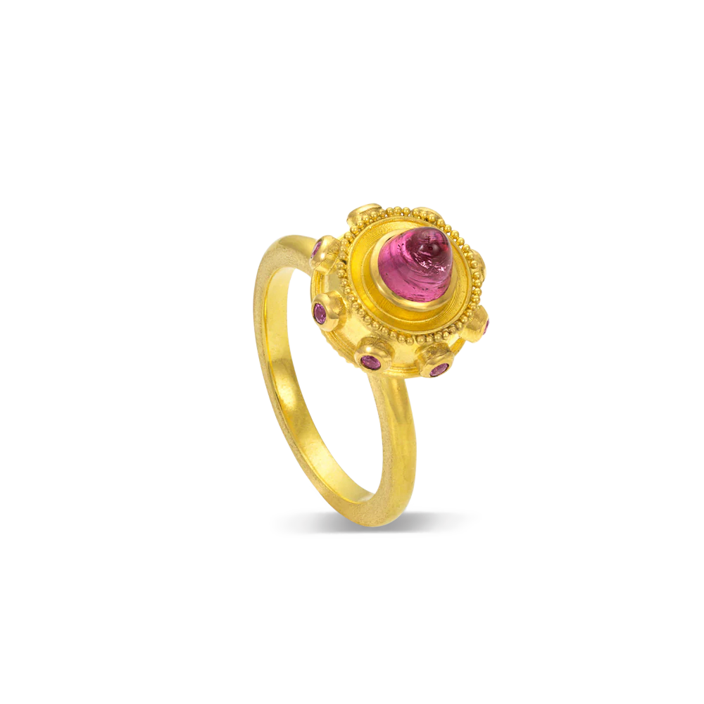 This charming ring is like a dainty bejeweled sphere, with a lovely central high dome bullet style richly colored pink tourmaline, with delicious purple grape garnets and golden granulation orbiting around it like tiny colorful moons.

Made in recycled 22k yellow gold, Mozambiquan tourmaline (.98ctw) and garnets from Orissa, India (.15ctw). Size 6.5. Can be resized.