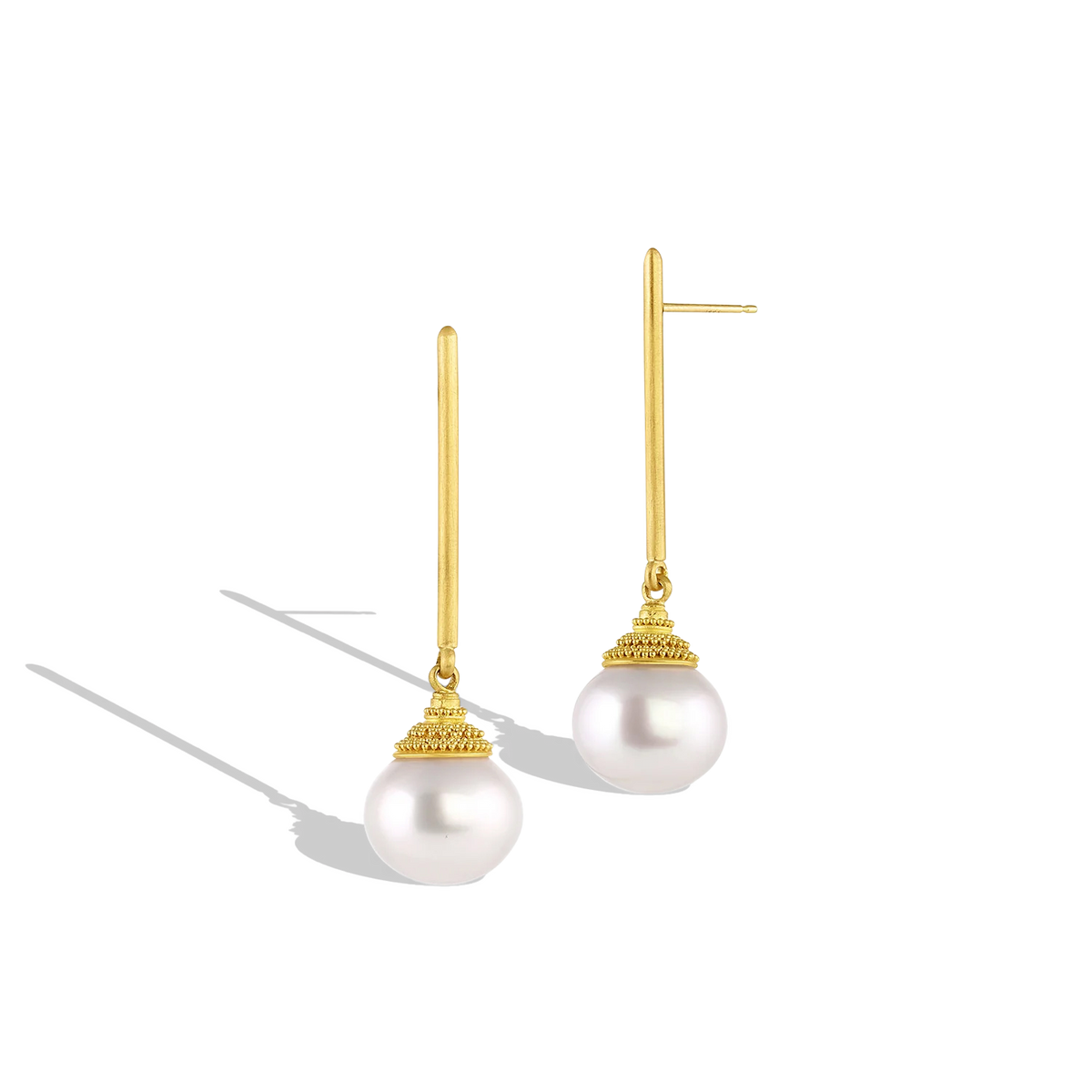 Golden pagoda style caps covered in tiny granulation perch atop button shaped South Sea pearls. Long, elegant brushed golden sticks allow the pearls to swing gently from the ear, making these earrings unique and striking. Length approximately 48mm, width 13.7mm (L 1.8in W .54in). Made in recycled 22k yellow gold, 13mm Australian Paspaley cultured South Sea pearls.