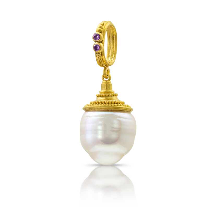 A beautiful circlé South Sea pearl acquired from Paspaley in Australia. - this one topped with a flared and circular granulated conical cap and bail. Lavender purple spinels are set on the bail. Length approximately 32 mm, width 13mm (L 1.26 x W .6 in).

Made from recycled 22k yellow gold, Burmese spinel (.04ct) and a 13mm Paspaley South Sea pearl.

One-of-a-kind.