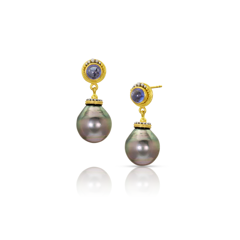 Semi baroque silver pearls with pink and blue overtones swing gently from violet blue tanzanite cabochons edged in our signature graduated polished platinum and soft buttery gold granulation. Post and Guardian back.

Handmade from recycled 22k gold and platinum, D Block tanzanite (1.37ct) and cultured 11-12mm Tahitian pearls. Length approximately 27mm or 1.06in.

One-of-a-kind.