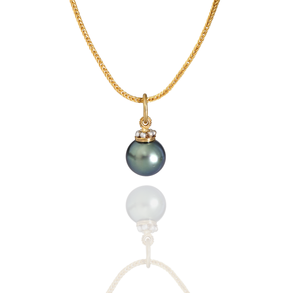 The Crown charm shown on a handwoven chain.