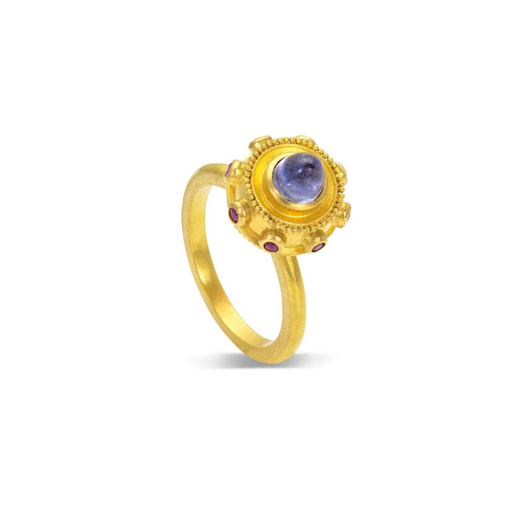 Reminiscent of a bejeweled Orb, instead of a customary cross mounted top it, this one has a soft violet blue tanzanite cut in a bullet style cabochon. A band of delicious purplish Anthill garnets and golden balls of granulation floats around it like miniature moons.

Made in recycled 22k yellow gold, responsibly sourced tanzanite (.93ctw) and garnets (.15cyw). Size 6.5. Made to order.