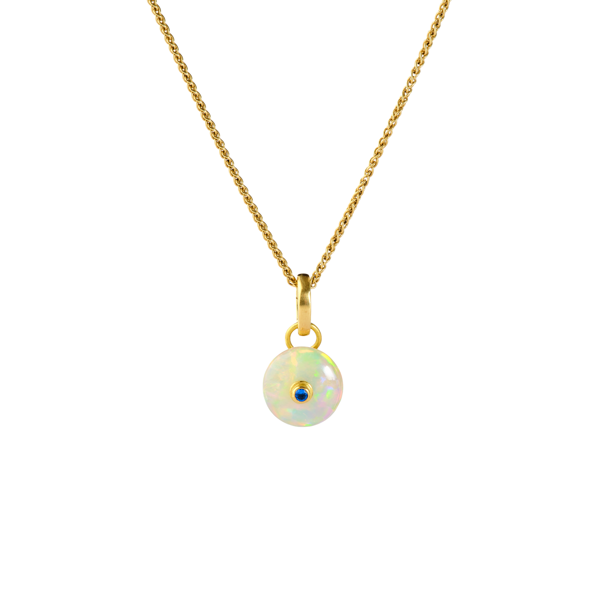 This beautiful opal from Ethiopia's Wollo province makes a timeless and stunning charm. With vivid flashes of red, orange, green and blue, a gold framed ultramarine haüyne is set in the center. Length and width approx. 20.5mm by 11mm (L .8in W .4in). The chain is available separately.

Made from recycled 18k gold, Ethiopian Welo opal (2.38ctw) and German haüyne (.03ctw).