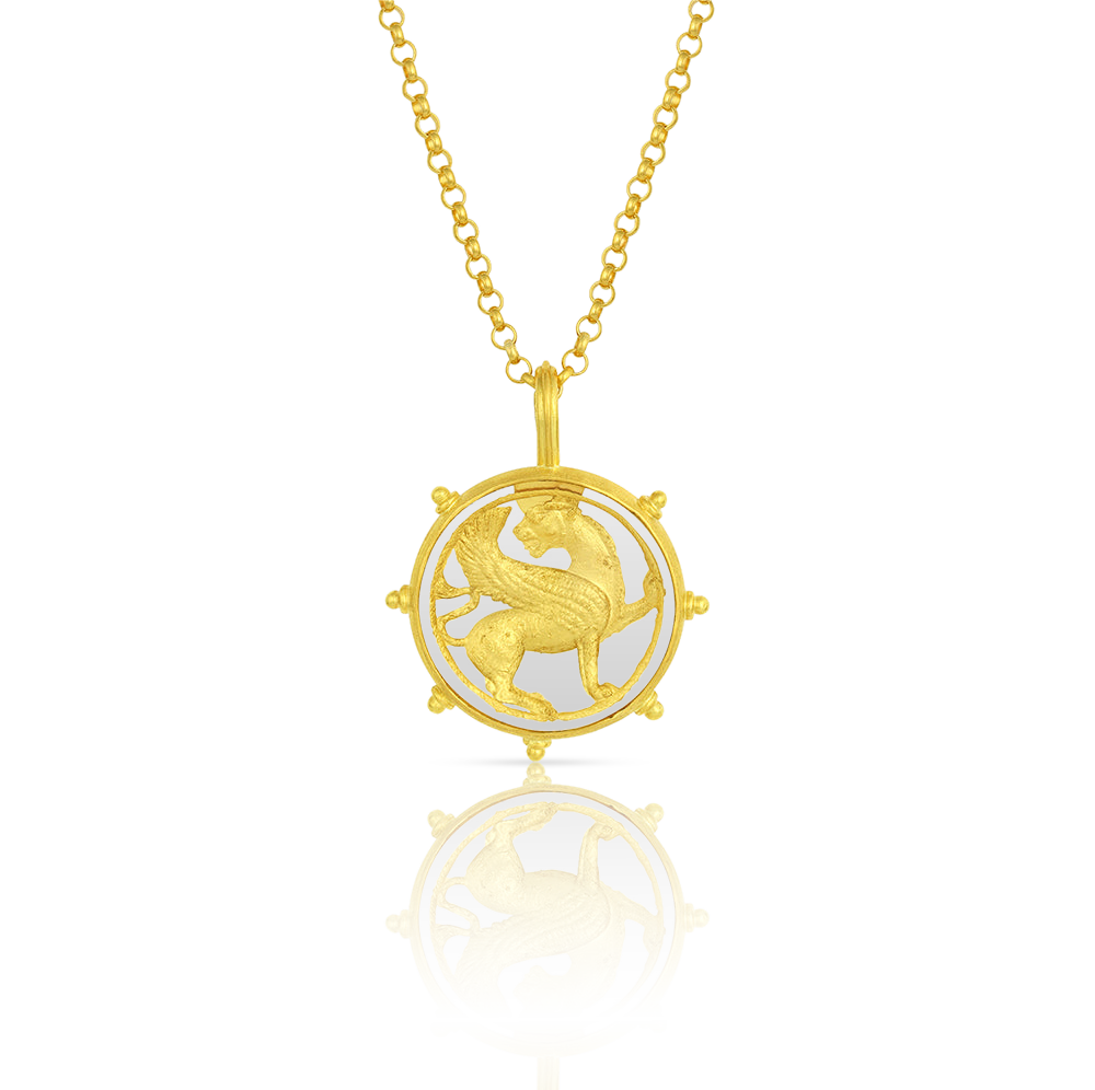 The Winged Lion charm shown on a handwoven gold chain.